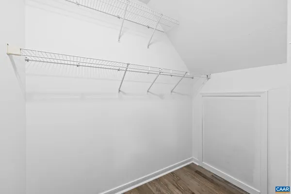 an empty room with wooden floor fireplace and windows