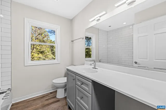 a view of a kitchen with wooden floor electronic appliances and stairs