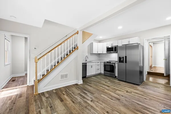 a view of an empty room with wooden floor