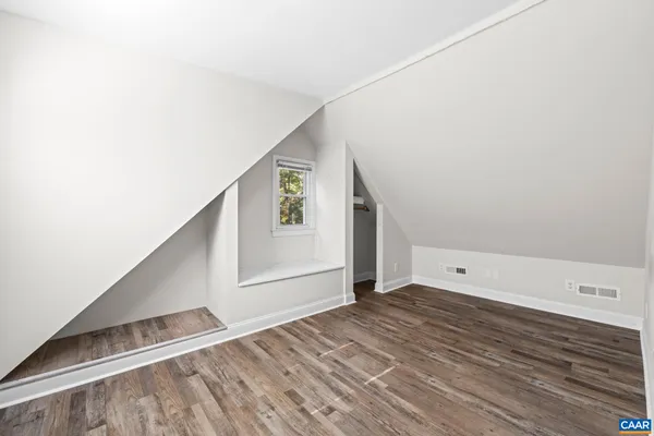 an aerial view of a houses with a yard and mountain view