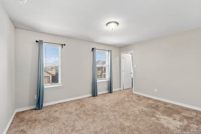 a view of an empty room with window and closet area