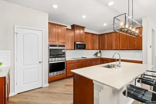 a kitchen with stainless steel appliances a sink cabinets and wooden floor