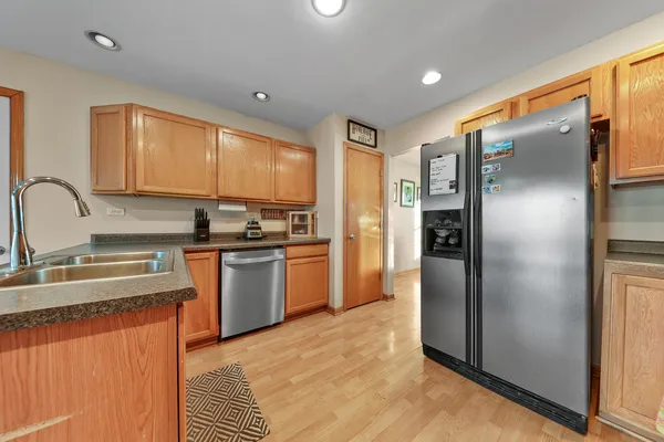a kitchen with stainless steel appliances granite countertop a refrigerator a sink a stove top oven and a refrigerator