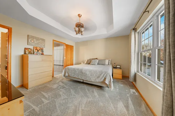 a bedroom with a large bed and a chandelier
