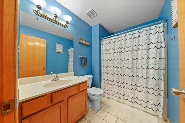 a bathroom with a sink a toilet and shower curtain