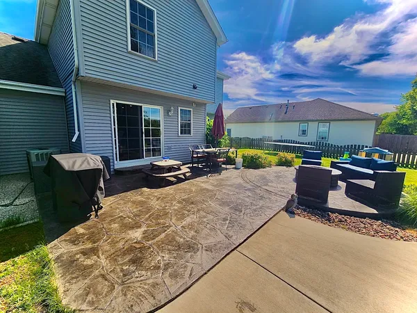 a view of a patio with table and chairs and a barbeque