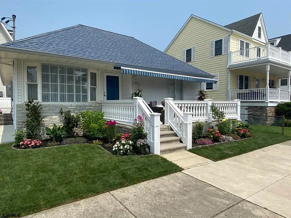 a front view of a house with a garden and plants