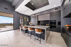 1313 Tortolita Mountain Circle Tucson, AZ 85755 - Photo 14 of 46 a kitchen with stainless steel appliances kitchen island granite countertop a table chairs and a refrigerator