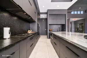 a kitchen with stainless steel appliances granite countertop a sink a stove and a wooden floors