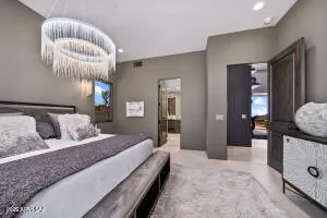 a spacious bedroom with a large bed and a chandelier