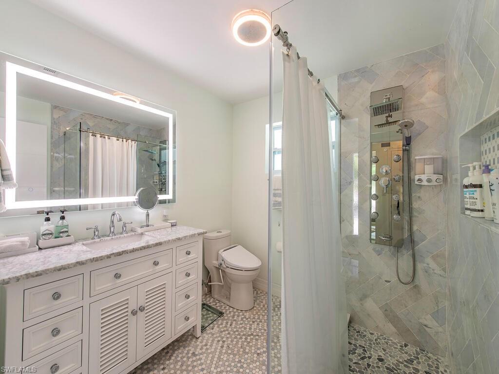 778 5th Avenue North Naples, FL 34102 - Photo 21 of 23 a spacious bathroom with a granite countertop sink toilet and shower