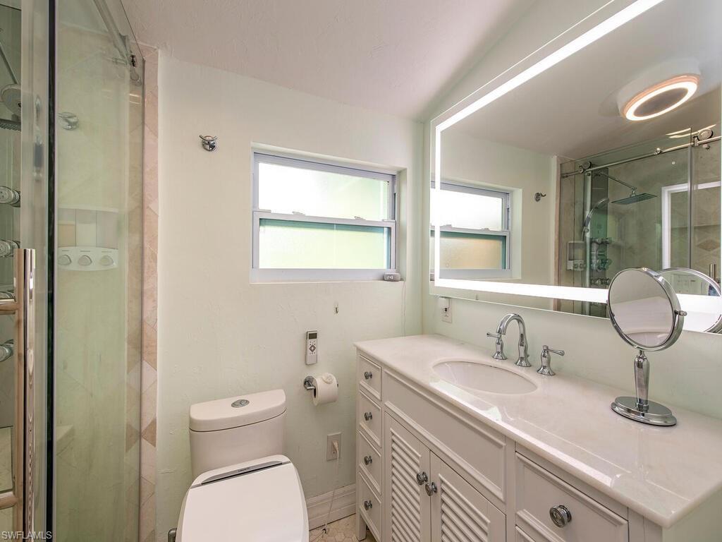 778 5th Avenue North Naples, FL 34102 - Photo 22 of 23 a bathroom with a granite countertop toilet sink and mirror
