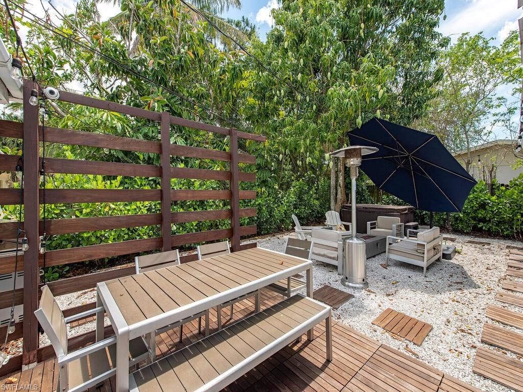 778 5th Avenue North Naples, FL 34102 - Photo 9 of 23 a view of a patio with a table and chairs under an umbrella