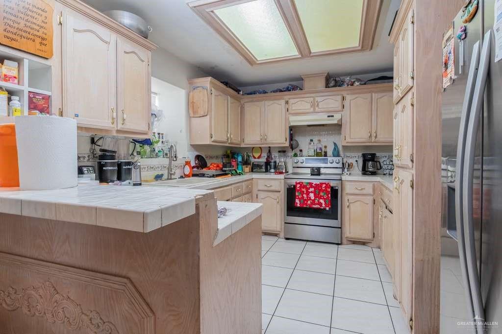 1821 Plainview Street Rio Grande City, TX 78582 - Photo 5 of 21 a kitchen with stainless steel appliances granite countertop a refrigerator sink stove and white cabinets