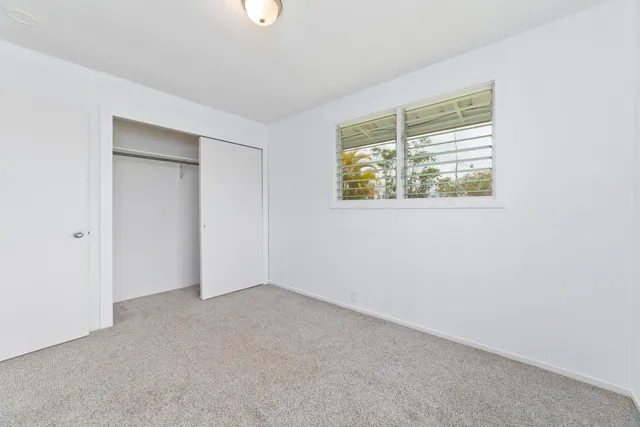 an empty room with windows and closet