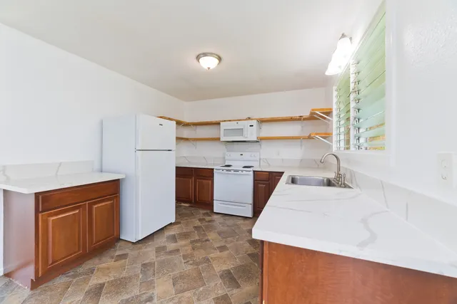 a kitchen with stainless steel appliances kitchen island granite countertop a sink a stove counter space and cabinets