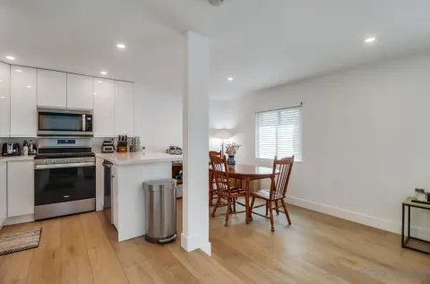 a kitchen with white cabinets and stainless steel appliances