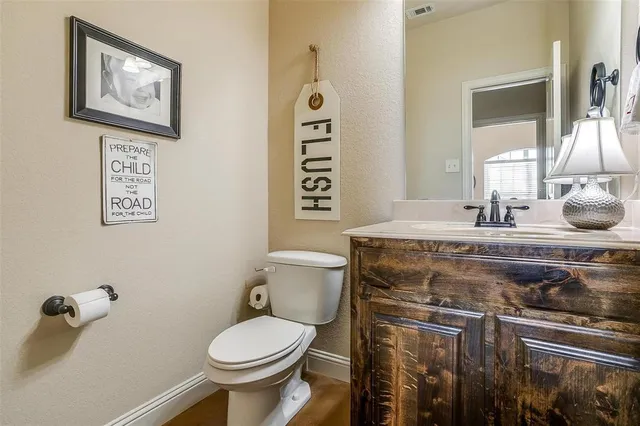 a bathroom with a granite countertop toilet sink and mirror
