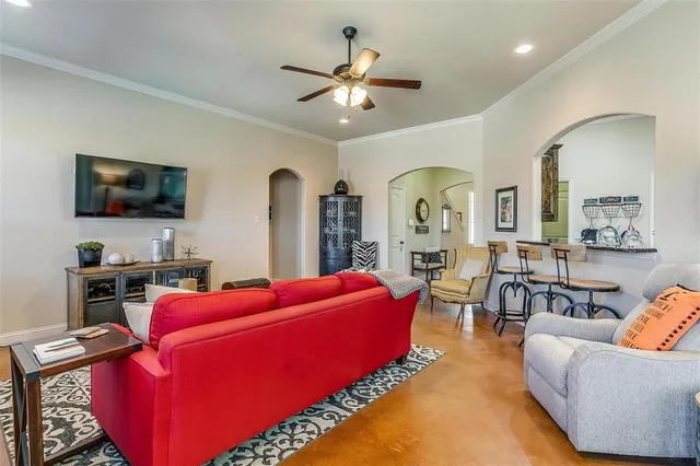 a living room with furniture a flat screen tv and a chandelier