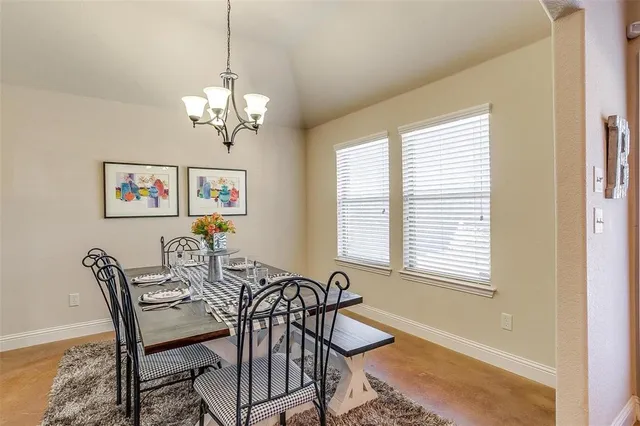 a view of a dining room with furniture a chandelier and a window