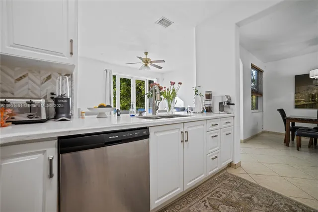 a kitchen with stainless steel appliances white cabinets a sink and a stove