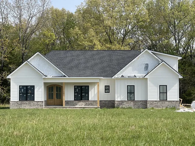 a front view of a house with a garden and yard