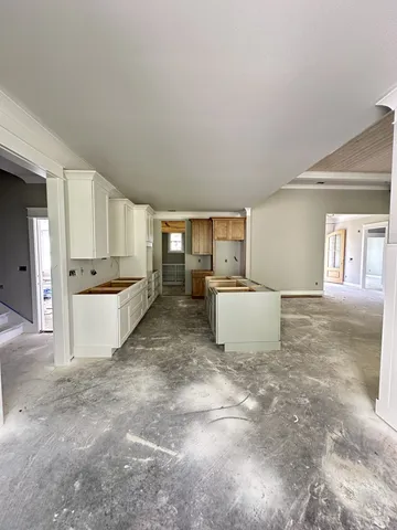 a kitchen with stainless steel appliances granite countertop a refrigerator sink and white cabinets