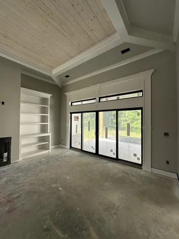 a view of an empty room with a fireplace and a window