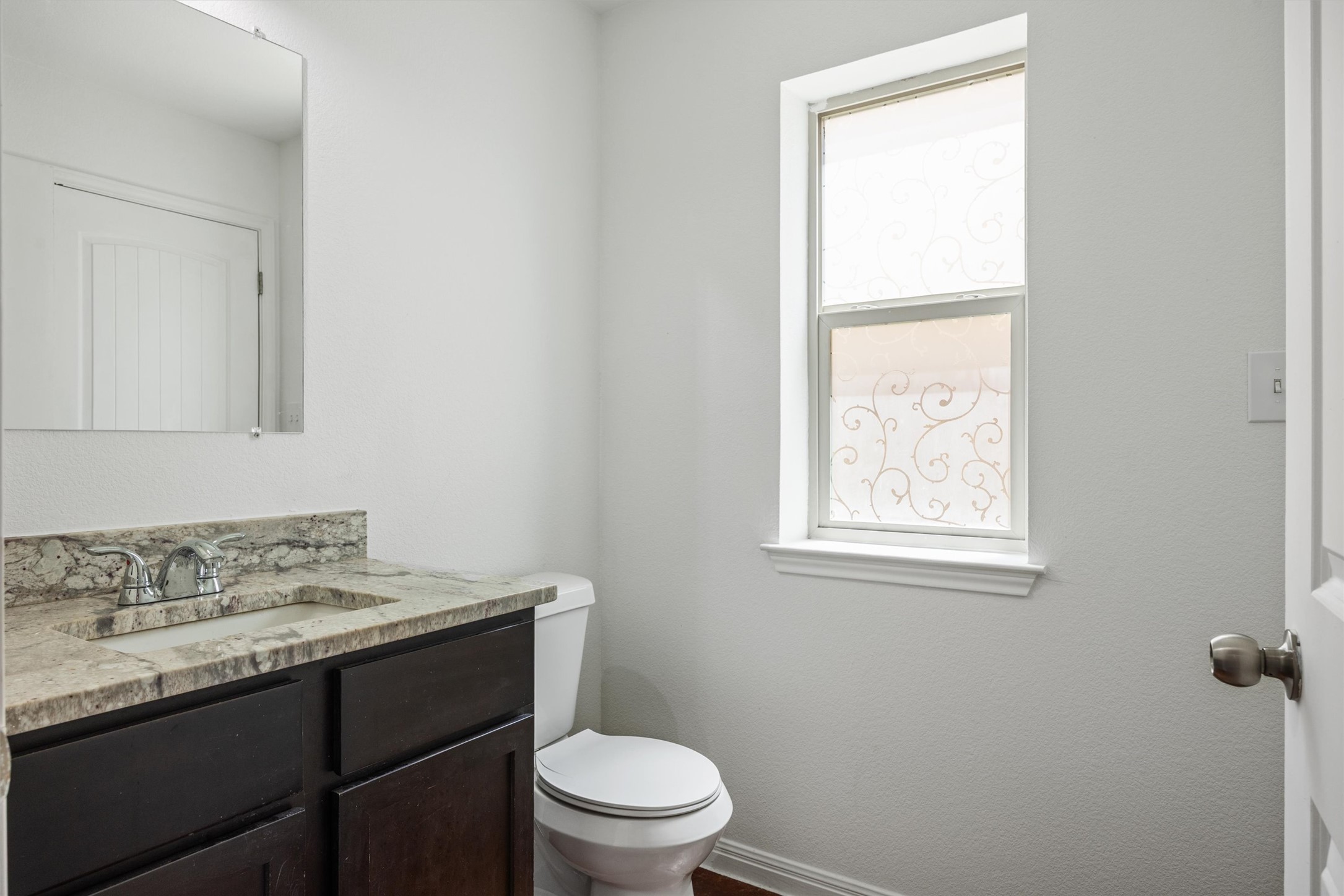 4516 Kind Way, Unit 253 Austin, TX 78725 - Photo 27 of 31 a bathroom with a granite countertop toilet a sink and a window