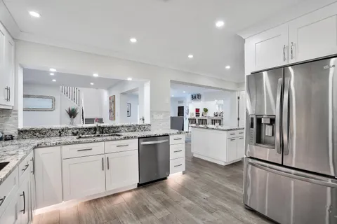 a kitchen with white cabinets and stainless steel appliances