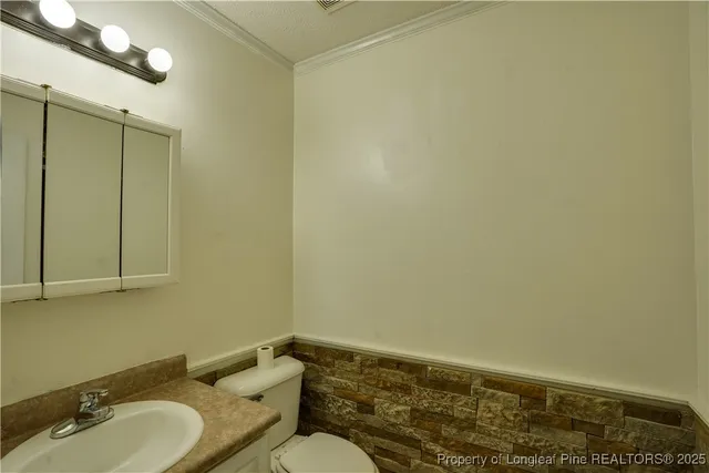 an empty room with wooden floor chandelier fan and windows