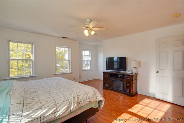 a bedroom with a bed and wooden floor