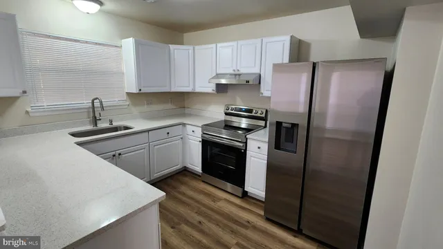 a kitchen with stainless steel appliances a refrigerator sink and cabinets