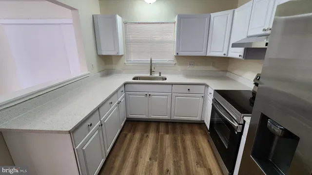 a kitchen with a sink a window stainless steel appliances and cabinets