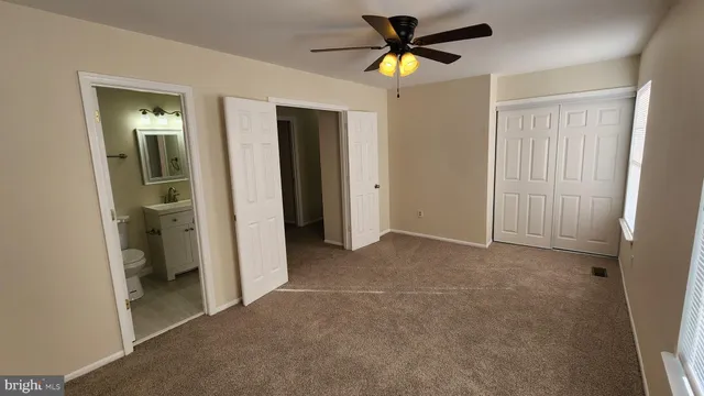 a view of a big room with closet and a chandelier fan