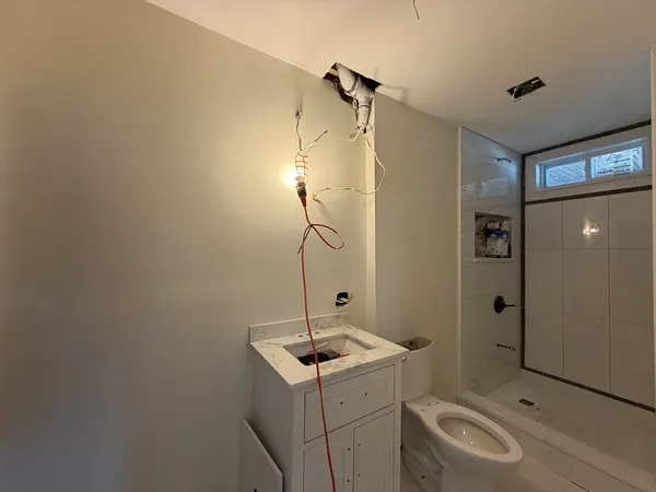 a bathroom with a sink a toilet and shower