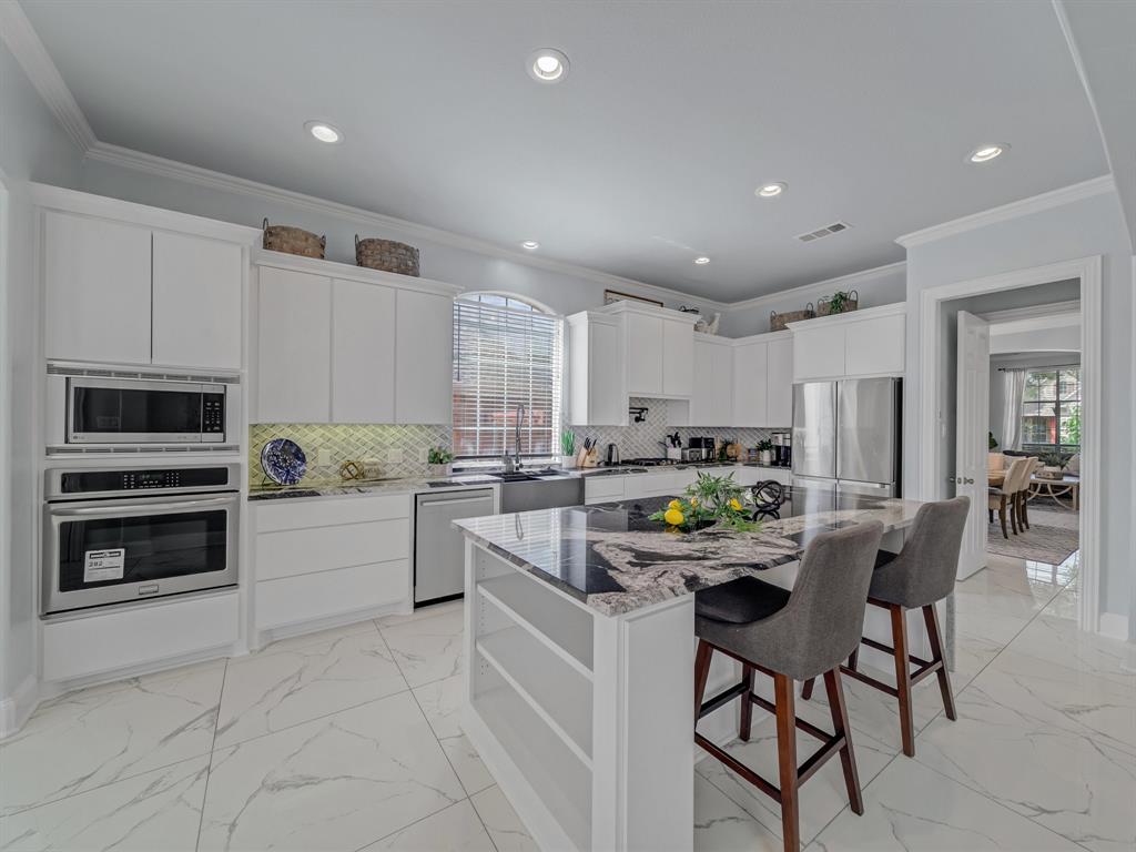 4332 Millsop Drive Carrollton, TX 75010 - Photo 17 of 37 a kitchen with a dining table cabinets and appliances