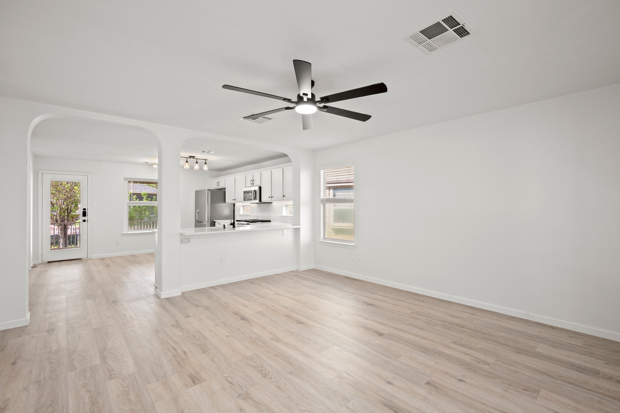 360 Sampson Kyle, TX 78640 - Photo 6 of 36 Open concept living area featuring light wood-finish flooring, a contemporary ceiling fan, and abundant natural light