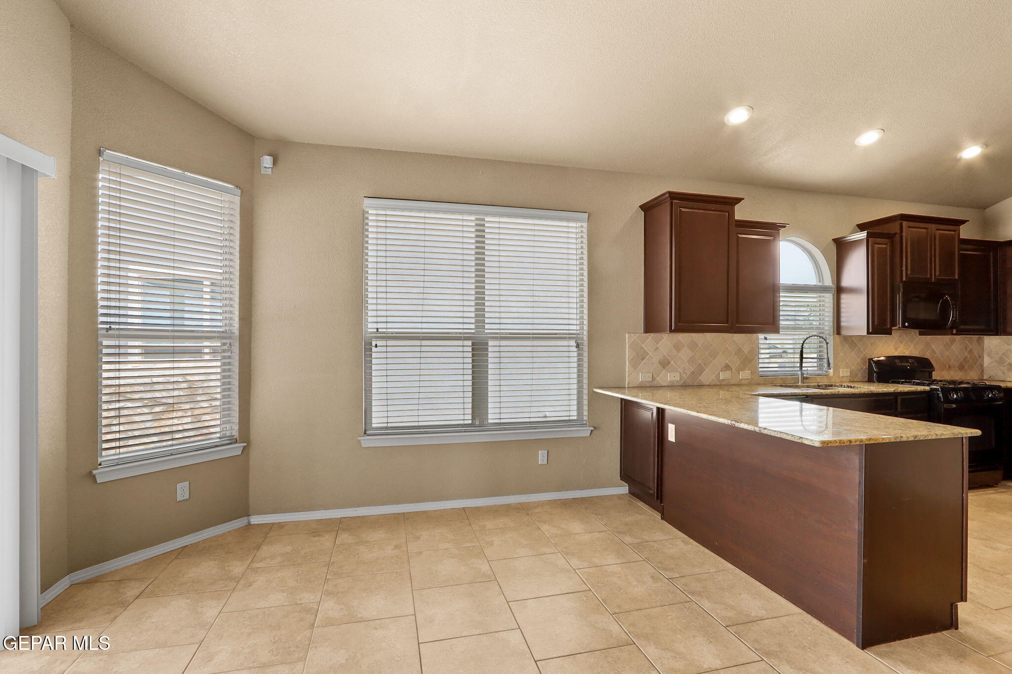 14353 Arabian Point El Paso, TX 79938 - Photo 11 of 48 a large kitchen with kitchen island granite countertop a sink and a stove top oven