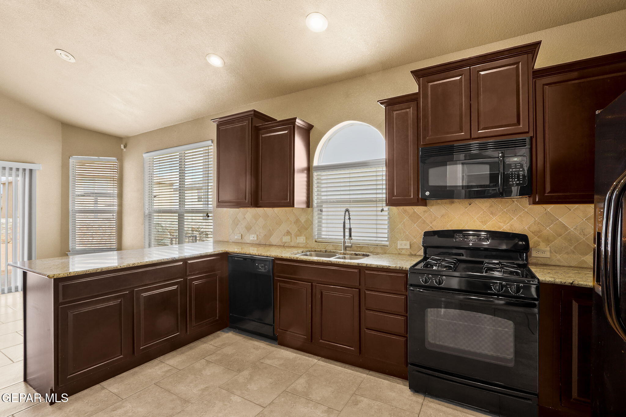 14353 Arabian Point El Paso, TX 79938 - Photo 13 of 48 a kitchen with stainless steel appliances a stove sink and cabinets