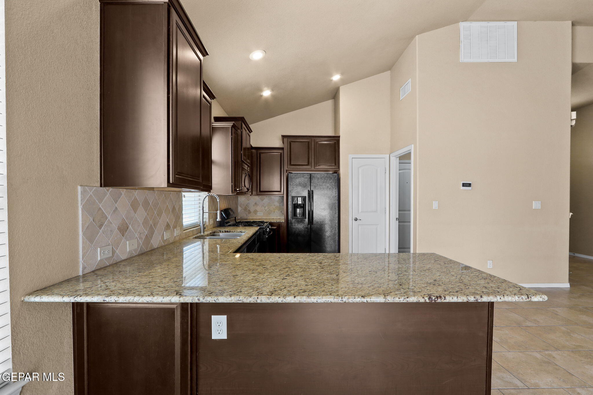 14353 Arabian Point El Paso, TX 79938 - Photo 18 of 48 a kitchen with stainless steel appliances granite countertop a sink a refrigerator and a granite counter tops