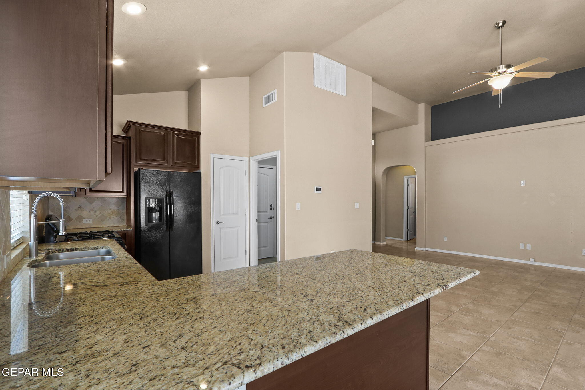 14353 Arabian Point El Paso, TX 79938 - Photo 19 of 48 a kitchen with stainless steel appliances kitchen island granite countertop a refrigerator and a sink