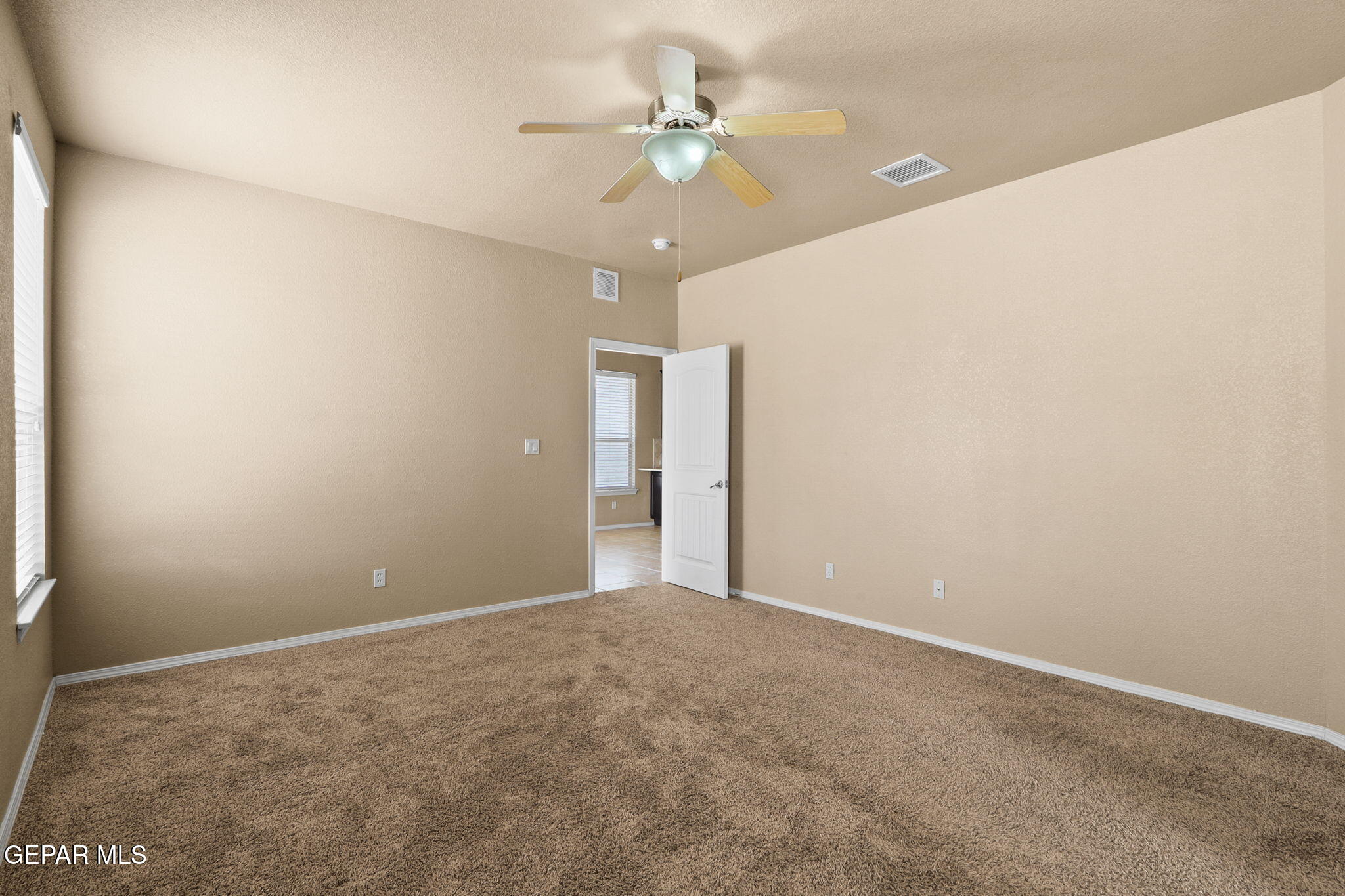 14353 Arabian Point El Paso, TX 79938 - Photo 21 of 48 an empty room with a chandelier fan and windows