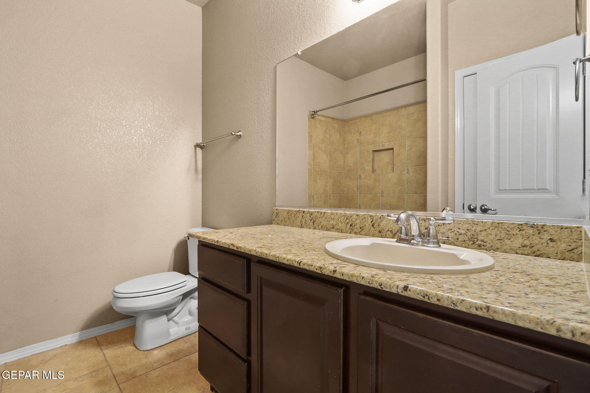 14353 Arabian Point El Paso, TX 79938 - Photo 30 of 48 a bathroom with a granite countertop sink a toilet and a mirror