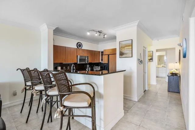 a kitchen with stainless steel appliances granite countertop a table and chairs in it