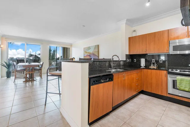 a kitchen with stainless steel appliances granite countertop a refrigerator and a stove top oven