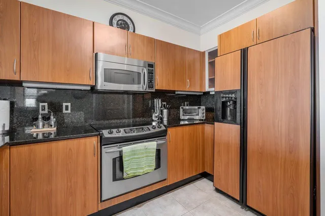 a kitchen with stainless steel appliances granite countertop a stove a sink and a microwave