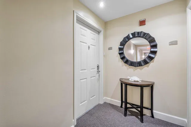 a front view of a house with wooden floor a sink and a mirror