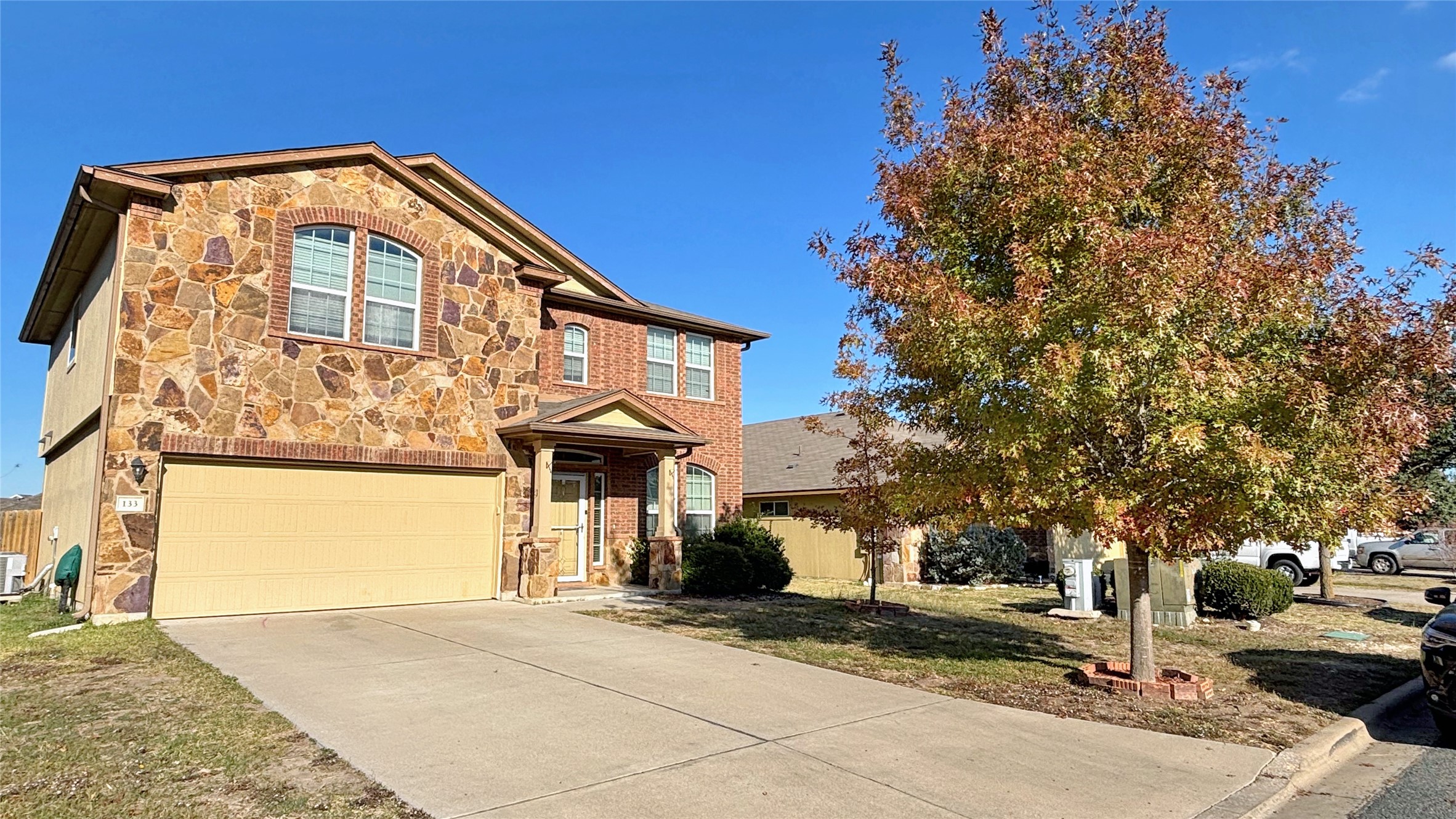 133 Langtry Lane Jarrell, TX 76537 - Photo 20 of 28 Traditional-style home featuring stone siding, an attached garage, a front yard, and driveway