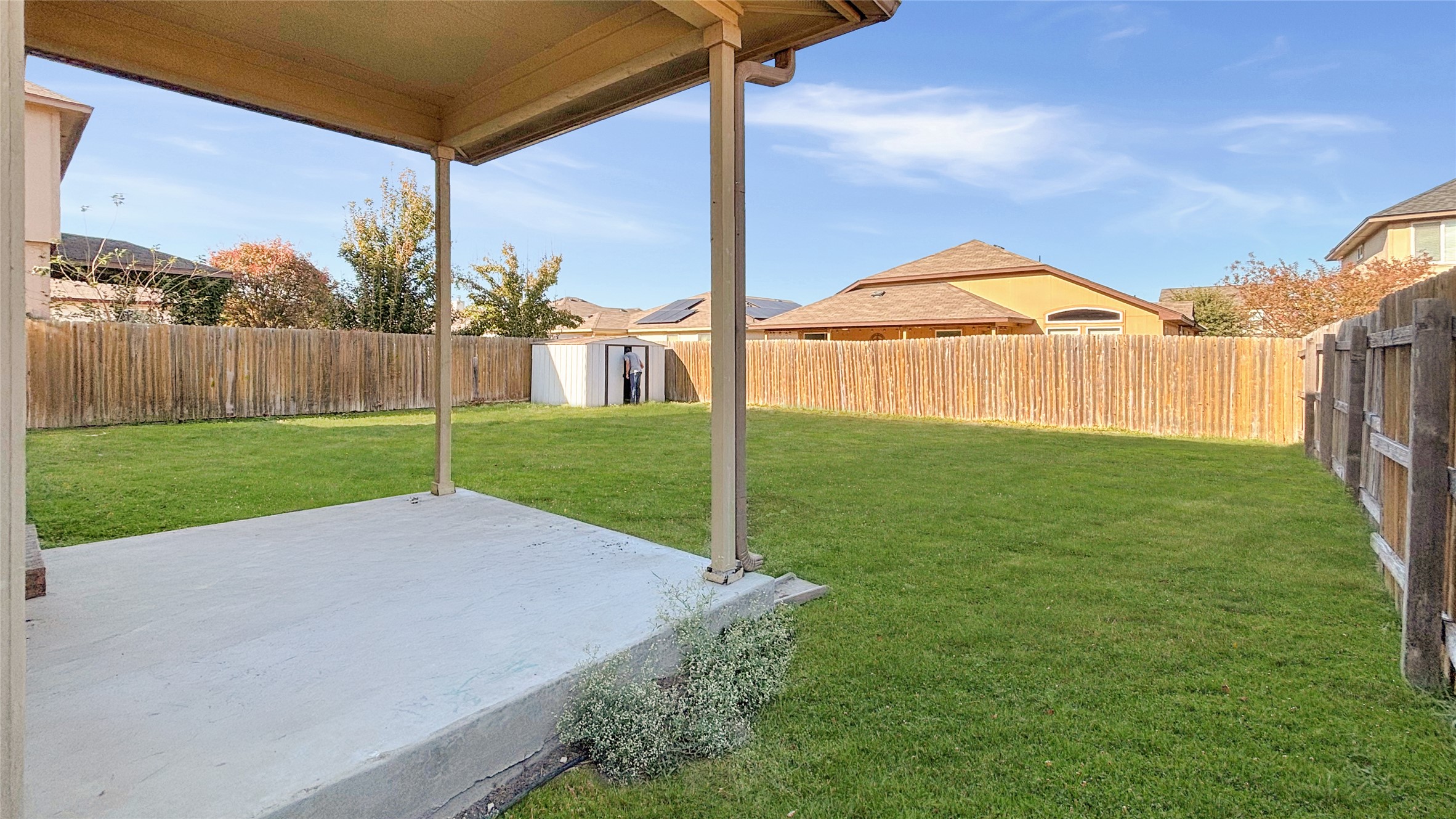 133 Langtry Lane Jarrell, TX 76537 - Photo 4 of 28 Back porch is covered, perfect for the Texas sun and fenced in yard with sprinklers. Fenced backyard.